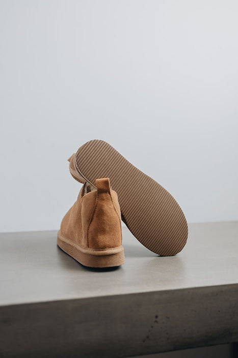 Close up of Tan coloured ankle-high sheepskin slipper showing the ribbed underside of the PVA sole