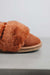 Close up of the toe of a rust coloured sheepskin slipper detailing the suede and wool collar