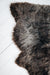 Soft Natural Brown British Sheepskin Rug contrasting against a hard and stark white wooden floor.
