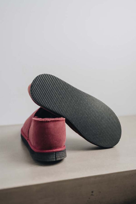 Close up of Bordeaux coloured loafer style sheepskin slipper showing the ribbed underside of the PVA sole