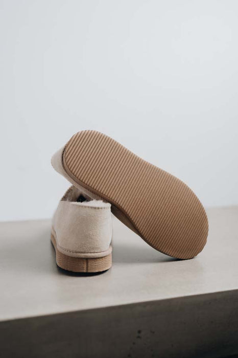 Close up of Vanilla coloured loafer style sheepskin slipper showing the ribbed underside of the PVA sole