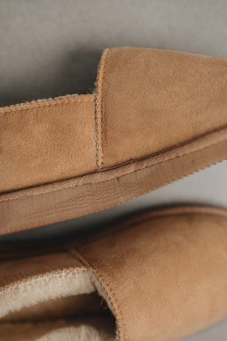 Close up of a clean loafer style tan sheepskin slipper, hand crafted from Spanish merino sheepskin.