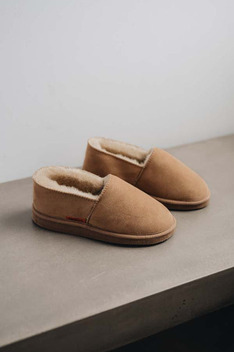 Side view of clean loafer style sheepskin slipper, hand crafted from Spanish merino sheepskin.