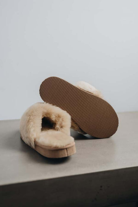 Veronica Leopard Sheepskin Slippers showing the bottom of the EVA sole on a Concrete Surface