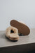Veronica Leopard Sheepskin Slippers showing the bottom of the EVA sole on a Concrete Surface