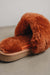 Close up view of Veronica Rust Sheepskin Slippers with Heatons label detail on Concrete Surface