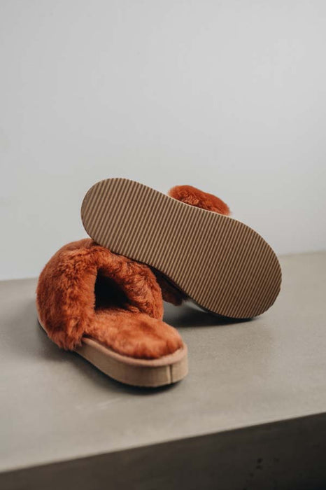 Women’s slip on sheepskin slippers for relaxed mornings - Veronica Rust Sheepskin Slippers showing the bottom of the EVA sole on a Concrete Surface