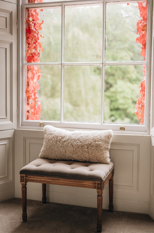 Rectangular bolster cushion made of patchwork sheepskin in a beige colour