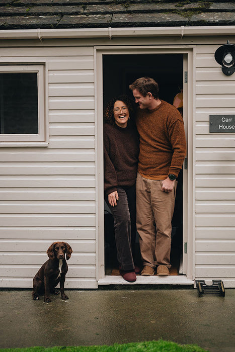 Tim and Dom  and their dog stood in doorway - Tim wearing Taupe Cadi Sheepskin Slippers.