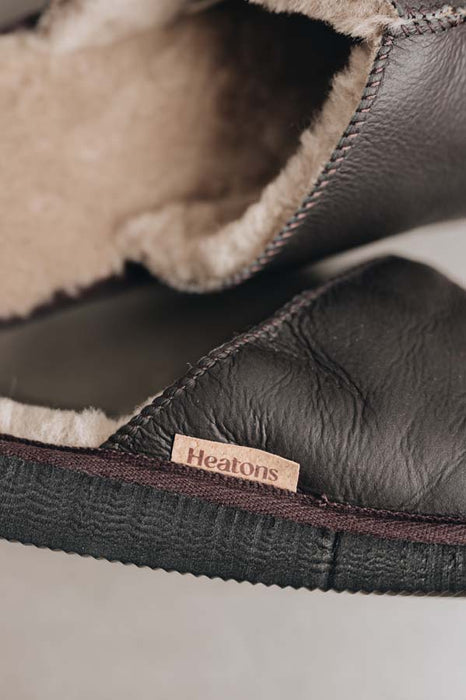Close up of nappa coffee coloured slip on style sheepskin slipper with natural cork label showing the Heatons brand
