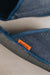 Close up of denim covered slip on style sheepskin slipper with orange cork label showing the Heatons brand